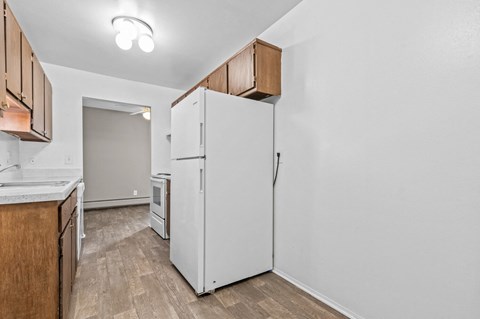 a kitchen with a white refrigerator and wooden cabinets