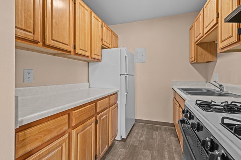 A kitchen with wooden cabinets and a white refrigerator.