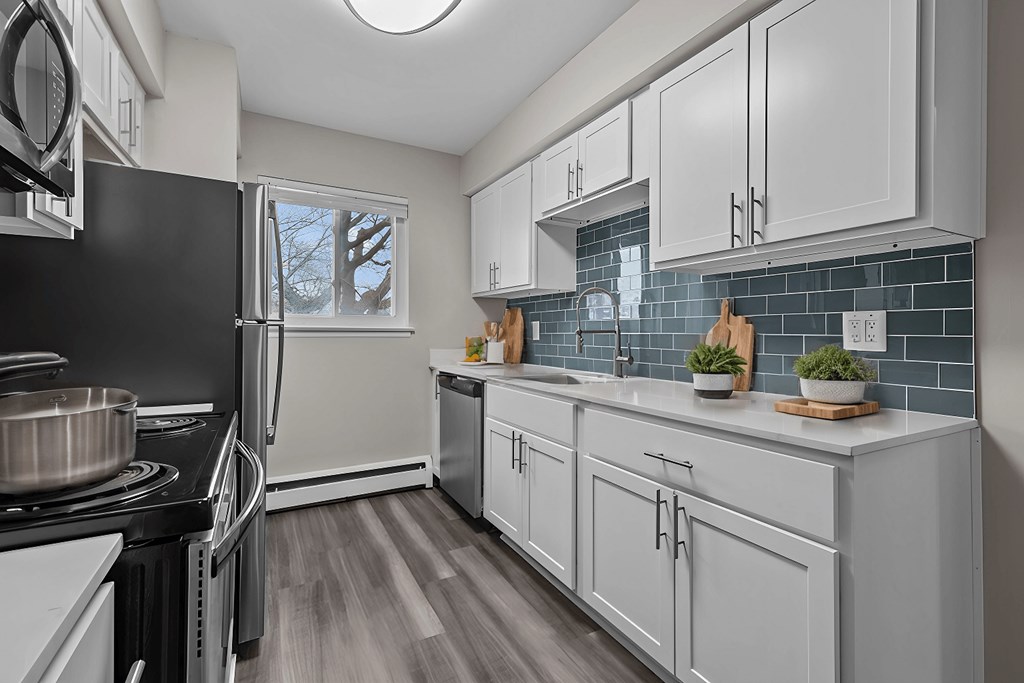 A kitchen with white cabinets and a black stove top.
