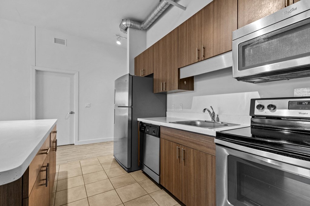 a kitchen with wooden cabinets and stainless steel appliances