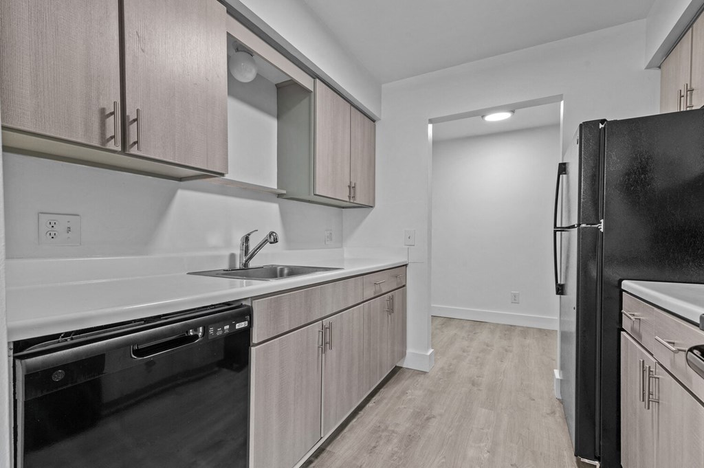 a kitchen with wooden cabinets and a black refrigerator