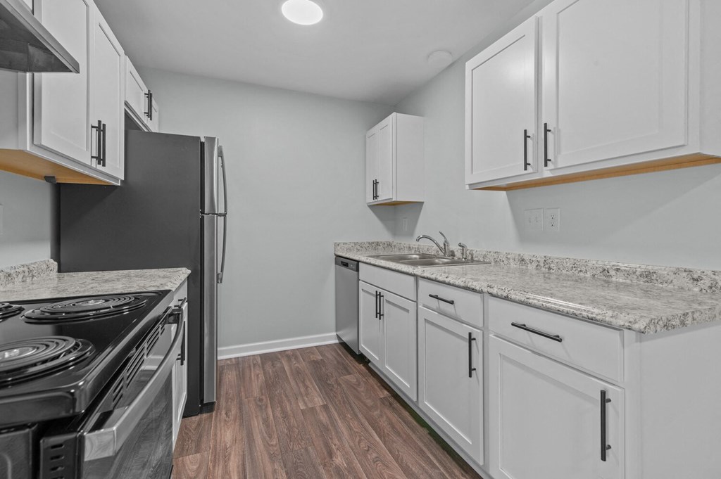 the kitchen in a new home with white cabinets and stainless steel appliances