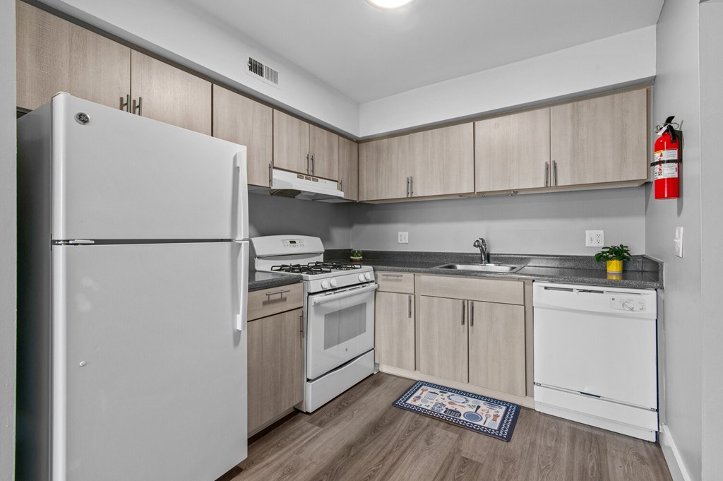 A kitchen with white appliances and wooden cabinets.