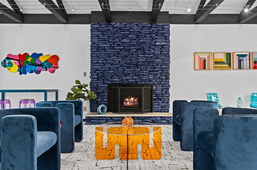 a living room with blue chairs and a fireplace