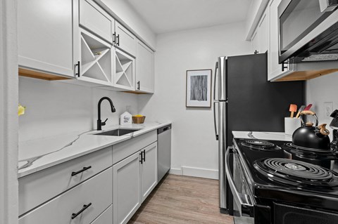 a kitchen with white cabinets and a black stove and refrigerator