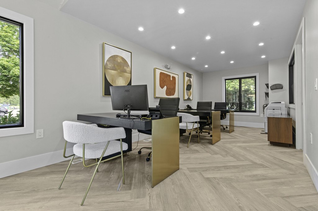 A modern home office with a desk, chairs, and a computer.