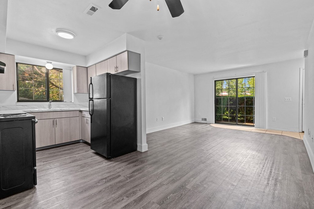 a kitchen and living room with wood floors and white walls