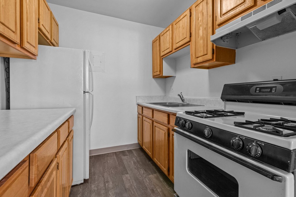 a kitchen with wood cabinets and white appliances and a refrigerator