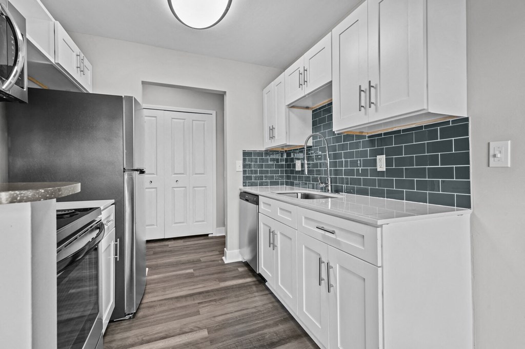 a white kitchen with stainless steel appliances and white cabinets at Sunnymede Apartments - Troy, MI, Troy, Michigan