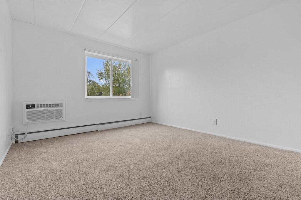an empty room with carpet and a window