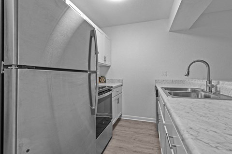 the kitchen of an apartment with stainless steel appliances and marble counter tops