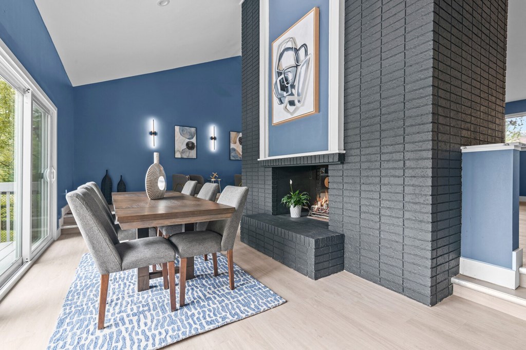 a dining room with blue walls and a wooden table and chairs