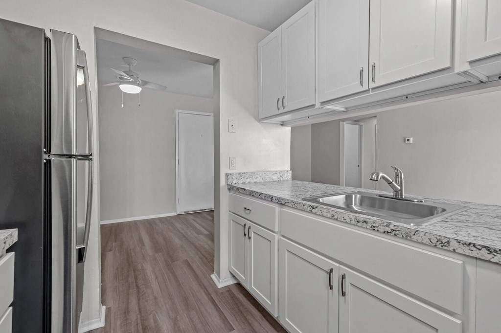 a kitchen with white cabinets and a sink and a refrigerator