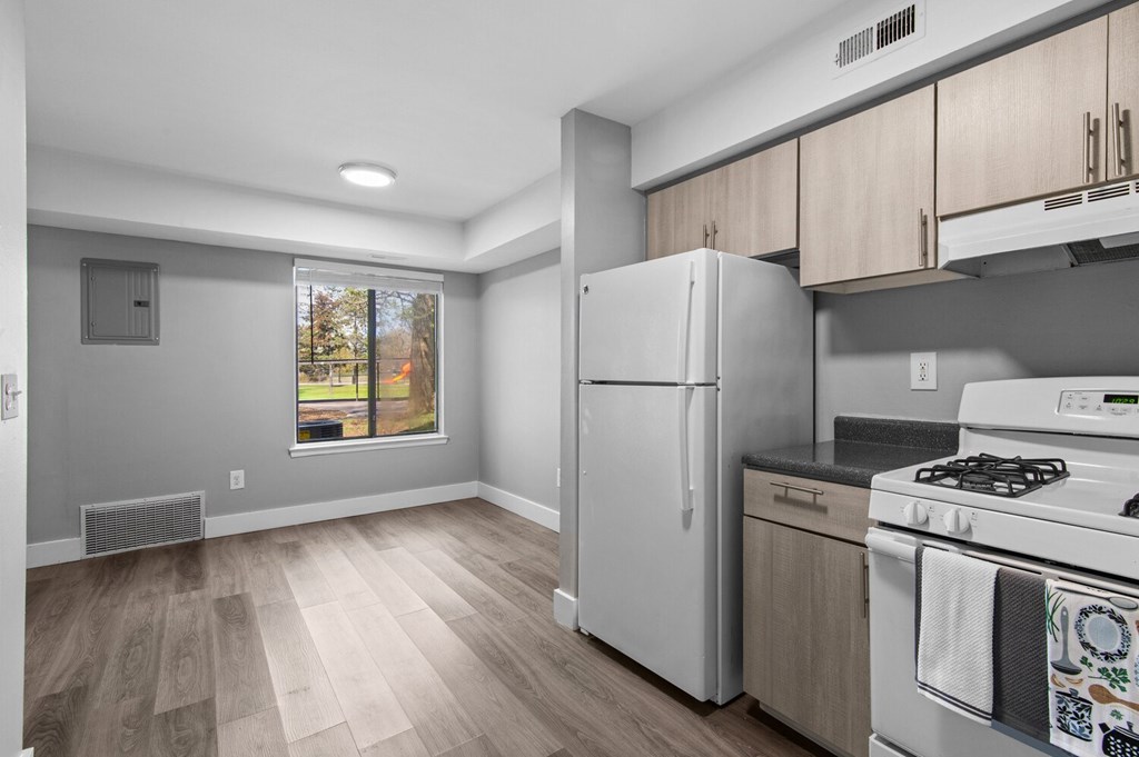 A kitchen with a white fridge and stove top oven.