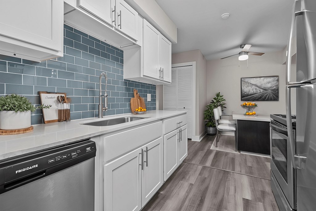 A kitchen with a black dishwasher and a black fridge.