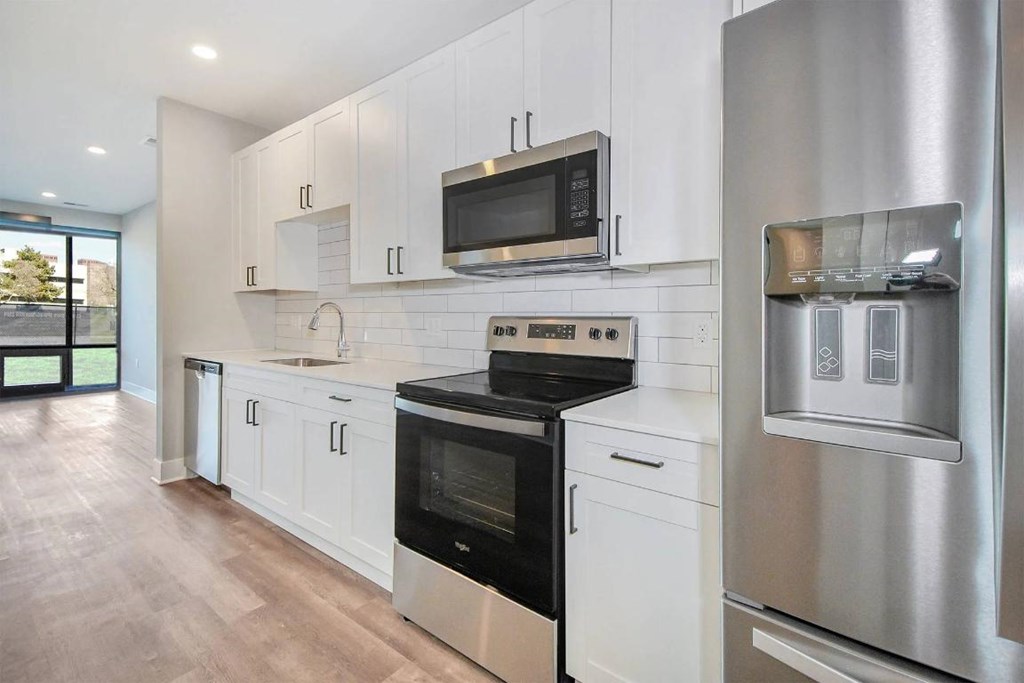A modern kitchen with stainless steel appliances and white cabinets.