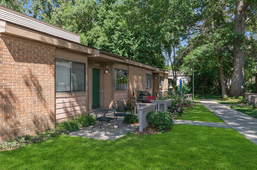 a patio with a table and chairs outside of a brick house