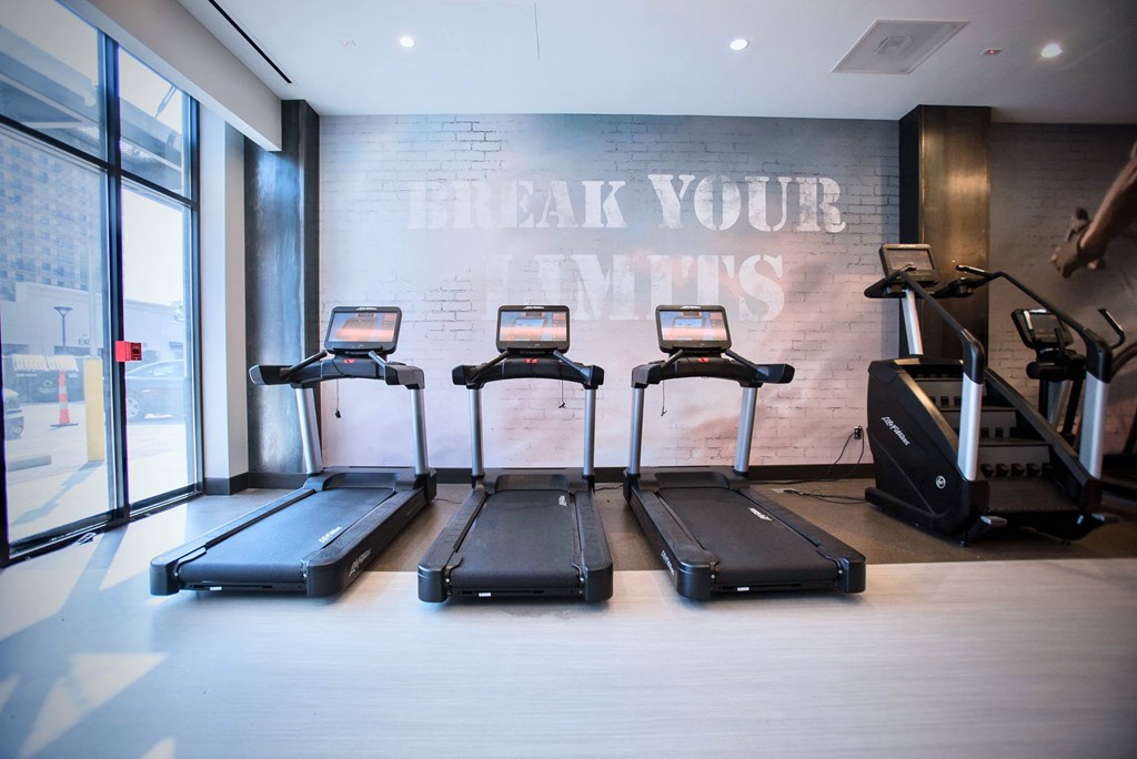 four treadmills in a gym with a wall that says break your vows