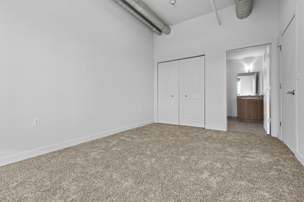 a bedroom with white walls and a carpeted floor