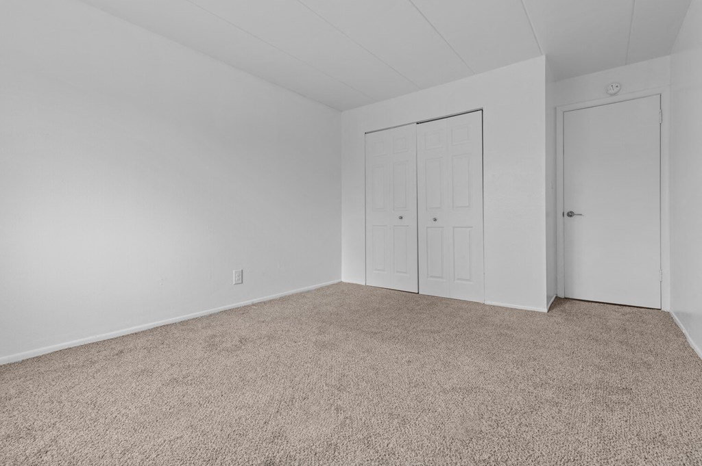 a bedroom with a carpeted floor and white doors