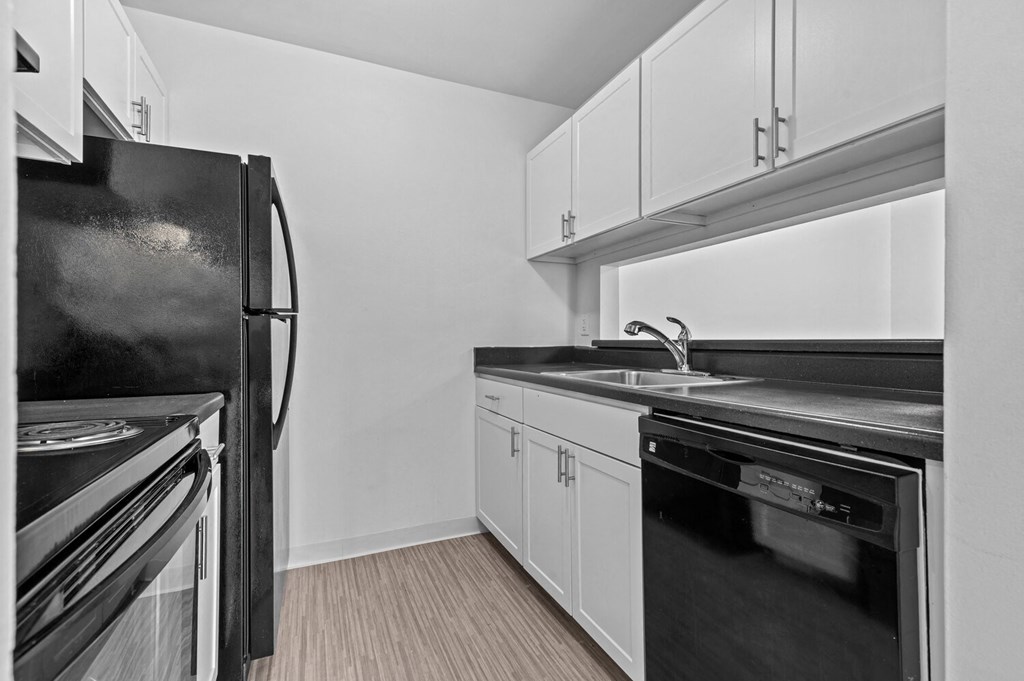 a kitchen with white cabinets and black appliances