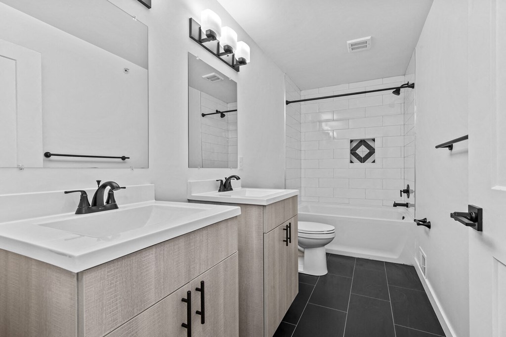 a white bathroom with two sinks and a toilet