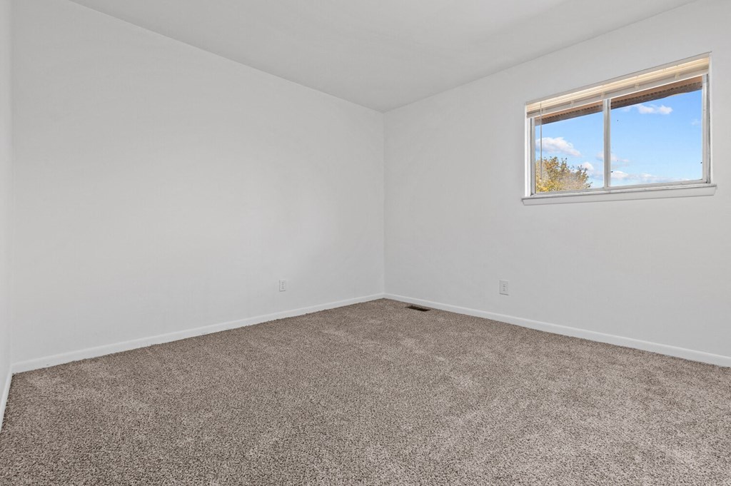 an empty room with carpet and a window