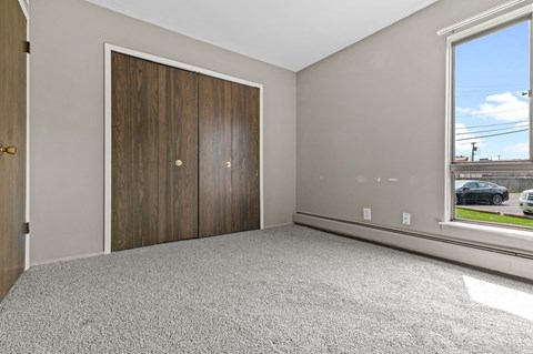 a bedroom with two doors and a large window