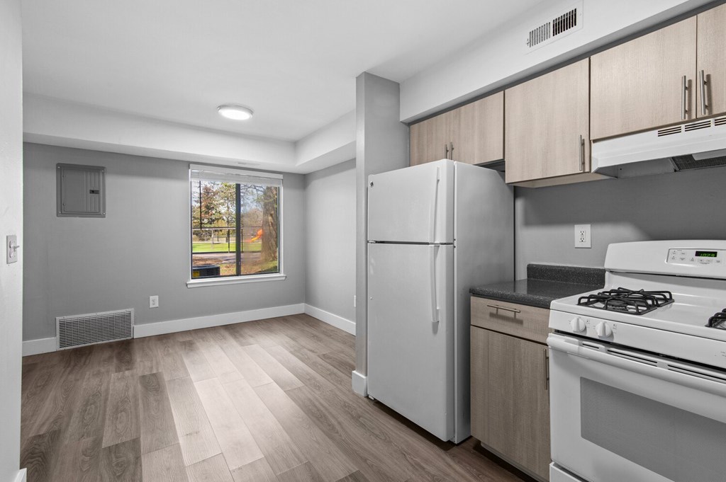 A kitchen with a white fridge and stove top oven.