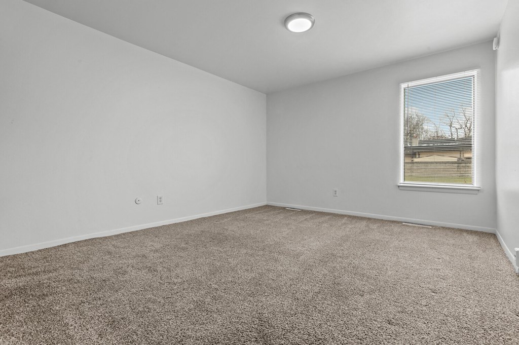 an empty room with carpet and a window
