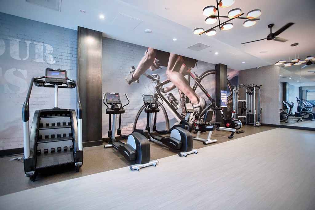a workout room with a wall mural of exercise bikes
