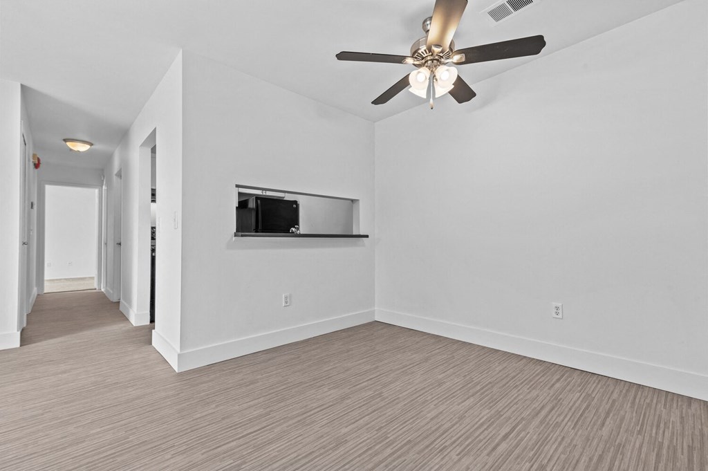a living room with a ceiling fan and a television
