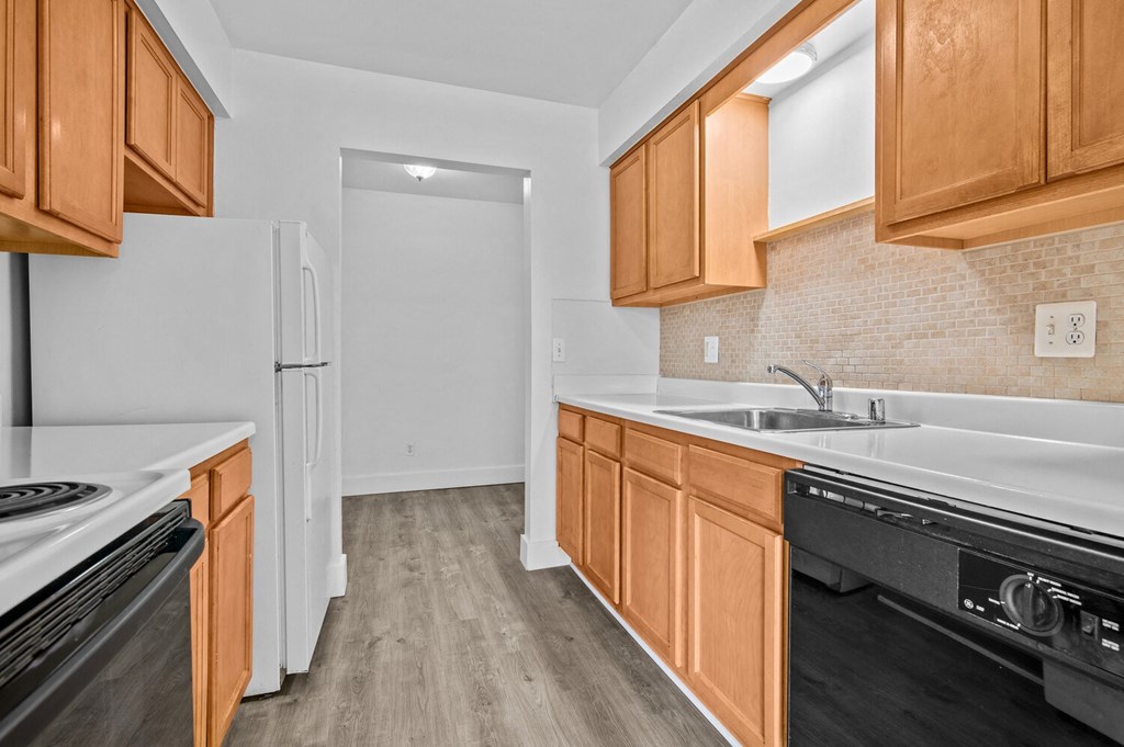 a kitchen with wooden cabinets and white appliances and a refrigerator