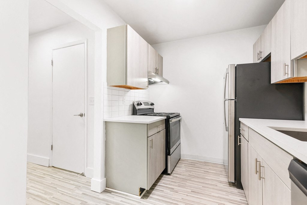a renovated kitchen with stainless steel appliances and white cabinets