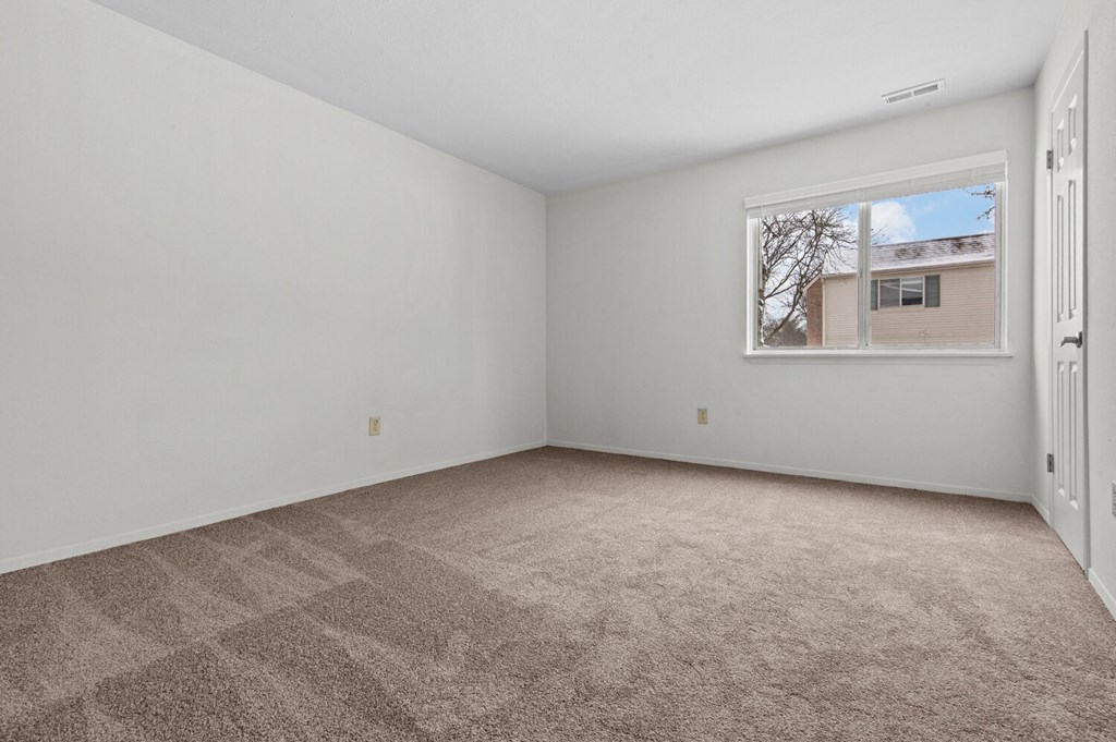an empty room with carpet and a window