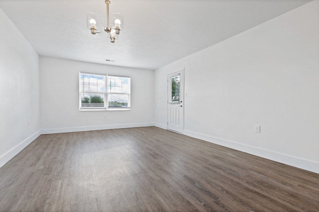 a bedroom with hardwood floors and white walls