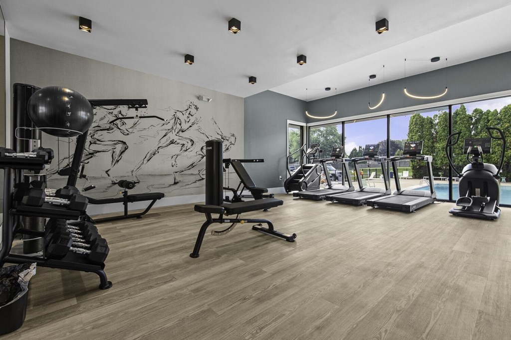 A gym with a variety of equipment including treadmills, weights, and exercise machines.