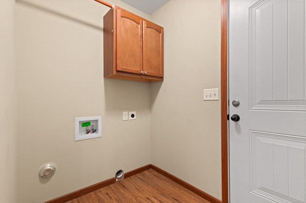 a room with a door and a cabinet on the wall and a wooden floor