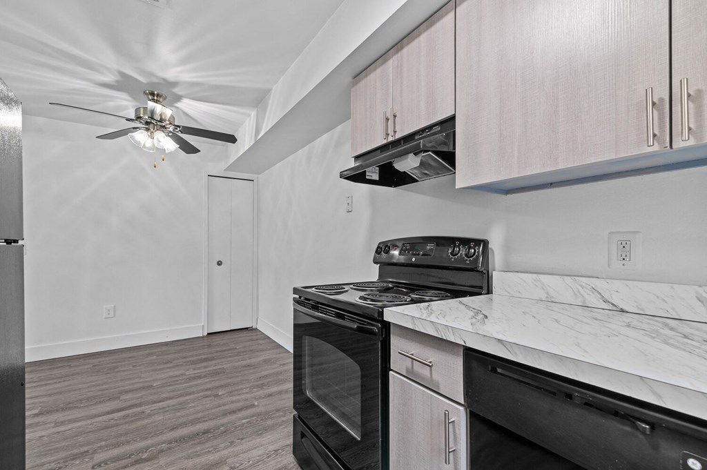 a kitchen with white cabinets and a black stove top oven