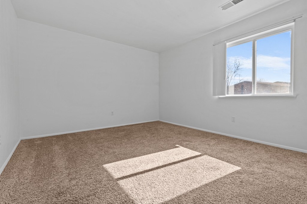 an empty room with carpet and a window