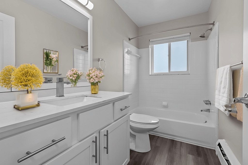 A white bathroom with a toilet, sink, and tub.