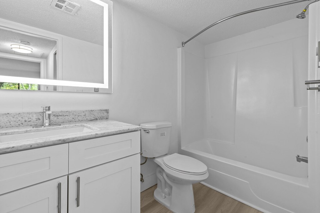 A white bathroom with a toilet, sink, and bathtub.