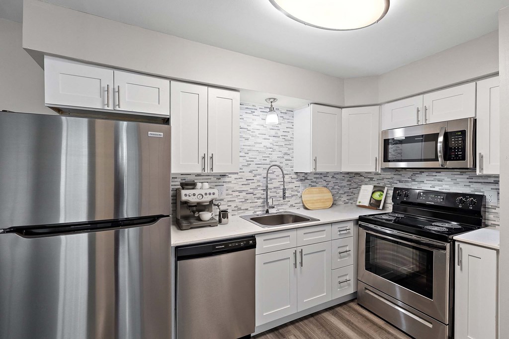 a kitchen with stainless steel appliances and white cabinets