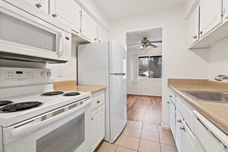 a kitchen with white appliances and a white refrigerator