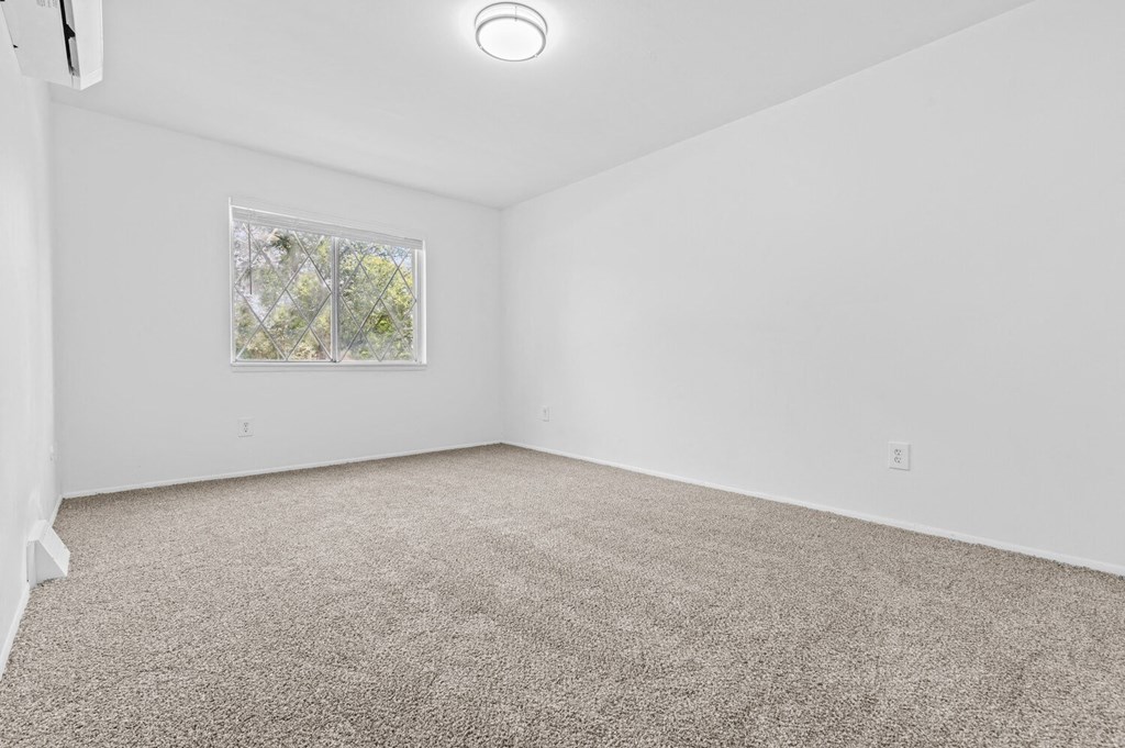 a bedroom with white walls and carpet
