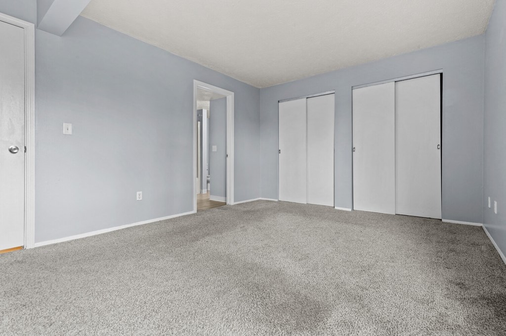 an empty living room with carpet and blue walls
