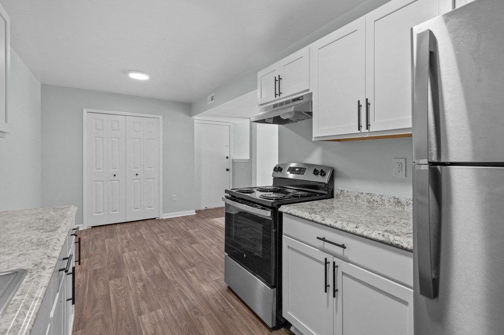 a renovated kitchen with white cabinets and stainless steel appliances