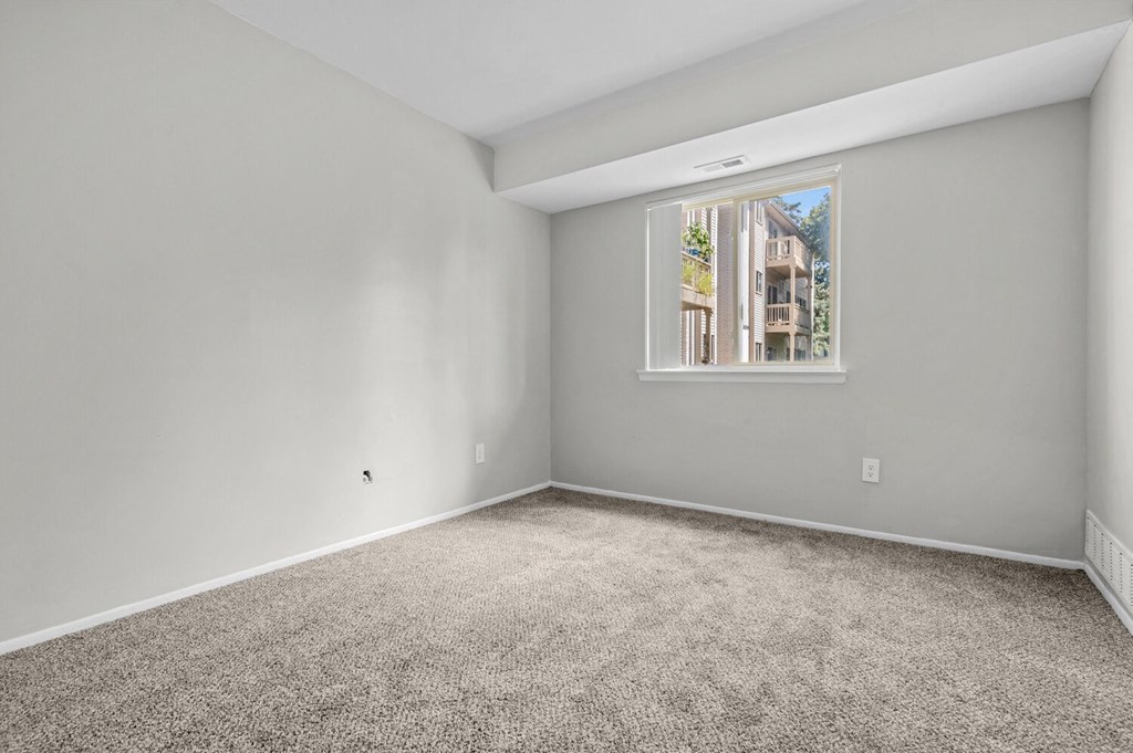 an empty room with carpet and a window