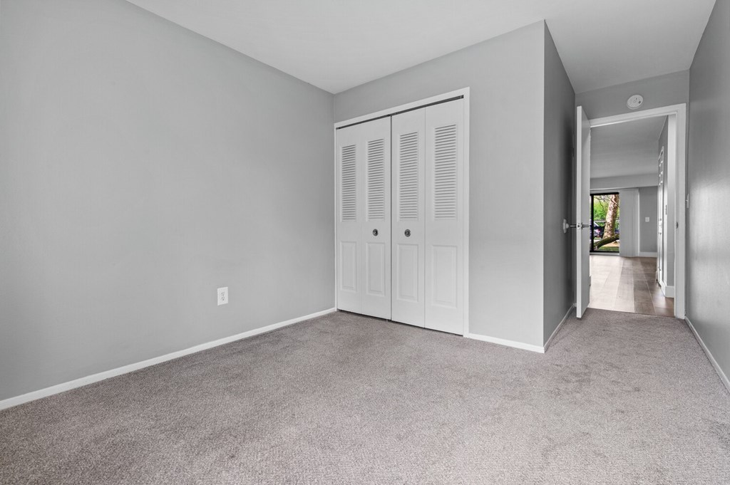 A room with a white door and carpeted floor.
