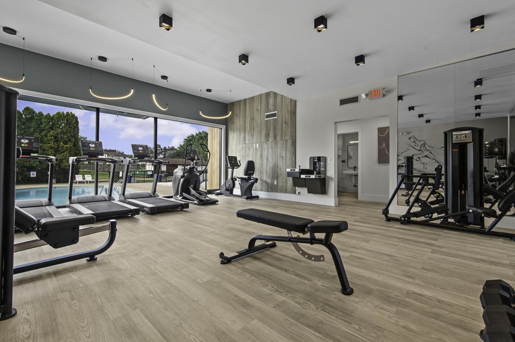 A gym with treadmills, weights, and exercise equipment.